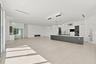 Spacious open-concept living area featuring polished concrete flooring, recessed and pendant lighting throughout, and a modern kitchen with dark cabin