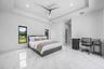 Spacious room featuring white tile flooring, tray ceiling, recessed lighting, and two windows