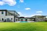 Expansive outdoor area featuring a swimming pool, covered patio, and large grassy lawn
