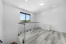 Upper-level landing featuring wood-finish flooring, glass railing, recessed lighting, and a contemporary ceiling fixture