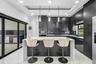 Contemporary kitchen featuring a large center island, dark cabinetry, sleek backsplash tiling, and integrated stainless steel appliances
