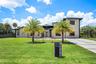 Contemporary exterior with a flat roofline, stucco finish, large windows, and a modern concrete driveway