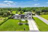 Contemporary architecture featuring a stucco exterior, dark trim windows, and a multi-level design