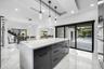 Kitchen island with a light-toned countertop, black cabinetry, and recessed lighting
