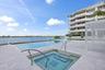 Waterfront property featuring a rectangular pool, integrated spa, and expansive patio with light-toned pavers