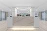 Lobby area featuring a stone-finish reception desk with integrated lighting, polished tile flooring, and recessed ceiling lighting