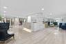 Lobby featuring polished stone-finish flooring, a reception desk with stone detailing, recessed lighting, and expansive window panels