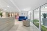Light-toned tile flooring, recessed ceiling lighting, a reception desk with wood-finish paneling, and an interior planter with decorative white stones