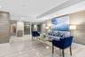 Polished stone flooring, recessed lighting, floor-to-ceiling windows, and wood-finish accent walls define this space