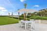 Expansive patio featuring a square umbrella and a rectangular table