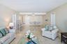 Expansive open-concept living space with polished tile flooring, recessed lighting, and neutral wall tones