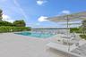 Outdoor swimming pool with integrated steps, surrounded by a stone paver deck