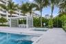 Swimming pool with integrated steps, adjacent spa, and surrounding light-toned paved deck