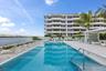 Resort-style pool area featuring a rectangular swimming pool, integrated entry steps, and a surrounding paver deck