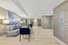 Marble-style tile flooring, wood-finish wall paneling, and an integrated lighting system create a refined space