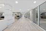 Reflective tiled flooring, recessed lighting, wood-finish wall panels, and full-height glass partitions