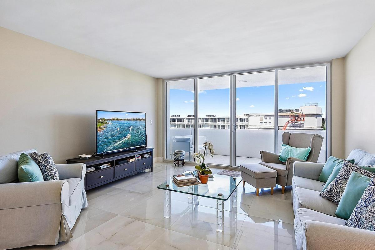 Expansive glass sliding doors to balcony, light-toned wall color, and polished tile flooring