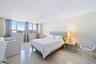 Expansive windows with city backdrop, light-toned walls, and large format tile flooring