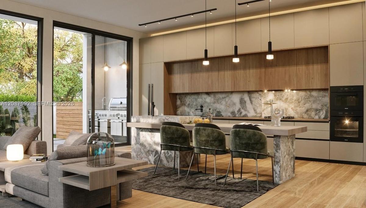 Wood-finish flooring, full-height glass doors, built-in ovens, stone slab backsplash, and integrated cabinet-front refrigerator