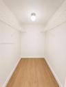 Recessed ceiling light, white walls, wood-finish flooring, and wire shelving