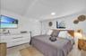 White walls, wood-finish flooring, recessed ceiling lighting, a window, and a built-in closet with sliding doors