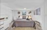 Light wood-finish flooring, white walls, and a recessed ceiling light