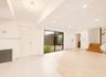 Expansive living space featuring a contemporary ceiling fixture, recessed lighting, and a full-height sliding glass door