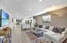 Open-concept living area featuring wood-finish flooring, recessed lighting, and a kitchen with stainless steel appliances