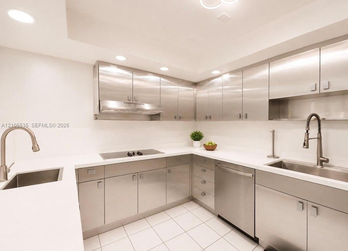 Modern kitchen featuring stainless steel cabinetry, white countertops, recessed lighting, and integrated stainless steel appliances