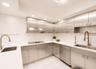 Modern kitchen featuring stainless steel cabinetry, white countertops, recessed lighting, and integrated stainless steel appliances