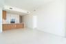 Open-concept living space featuring high ceilings, light tile flooring, built-in kitchen cabinetry with integrated appliances, and a kitchen island wi