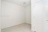 White ceramic tile flooring, recessed ceiling lighting, and a flush-mounted door with a modern handle