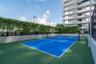 Multi-sport court with vibrant blue playing surface and green surrounds