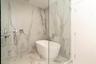 Freestanding tub within a glass-enclosed shower, featuring large format wall and floor tiling, and polished chrome fixtures
