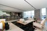 Integrated wet bar with barstool seating, recessed track lighting, full-height windows with sheer window treatments, concrete accent wall, and light-t