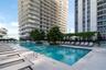 Resort-style pool with integrated steps, surrounding lounge area, and modern high-rise architecture