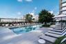 Outdoor swimming pool with surrounding lounge area, paver decking, and mature landscaping