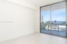 Sliding glass doors opening to a private balcony, offering expansive water and city scenery