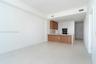 Open-concept kitchen featuring wood-finish cabinetry, integrated oven, and a white countertop with a matching backsplash