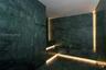 Green marble-style tile walls and flooring with integrated linear lighting