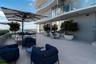 Expansive outdoor terrace featuring light-toned large format tile flooring, modern architectural lighting, and abundant natural light