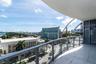 Balcony featuring glass railings, a tiled floor, and a curved ceiling