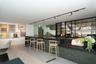 Bar area featuring a dark countertop, integrated shelving with glass accents, and wood-finish flooring