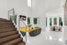 Two-story entry with wood-finish staircase, stainless steel railing, high ceilings, large format tile flooring, and multiple windows