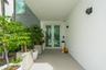 Covered entry featuring a light-toned concrete walkway, architectural wall sconces, and a modern double-door entry