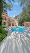 Rectangular swimming pool with integrated stairs, a spacious surrounding deck, and a detached gazebo structure