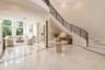 Grand foyer featuring a curved staircase with ornate wrought iron railing and wood handrail