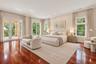 Rich wood-finish flooring with a large area rug