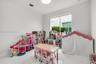 White-tiled flooring with smooth white walls, recessed ceiling lighting, and a large window