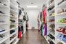 Walk-in closet featuring extensive built-in shelving, hanging rods, and wood-finish flooring